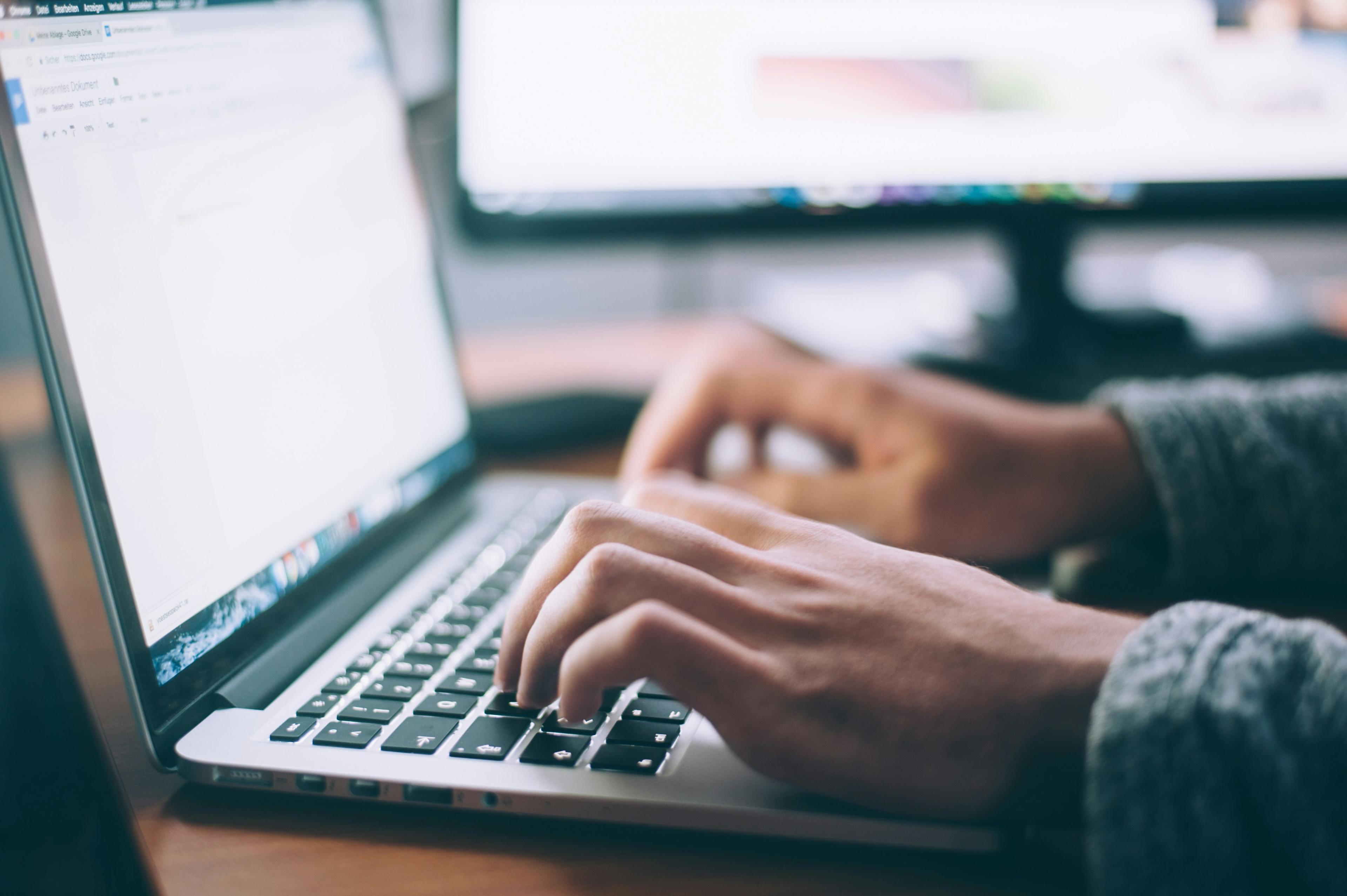 A writer working on an article on a laptop
